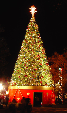 34 foot panel lighted holiday Christmas tree on top of red drum with lighted atar on top