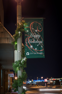 street pole lighted garland wrapped around city street pole with holiday banner