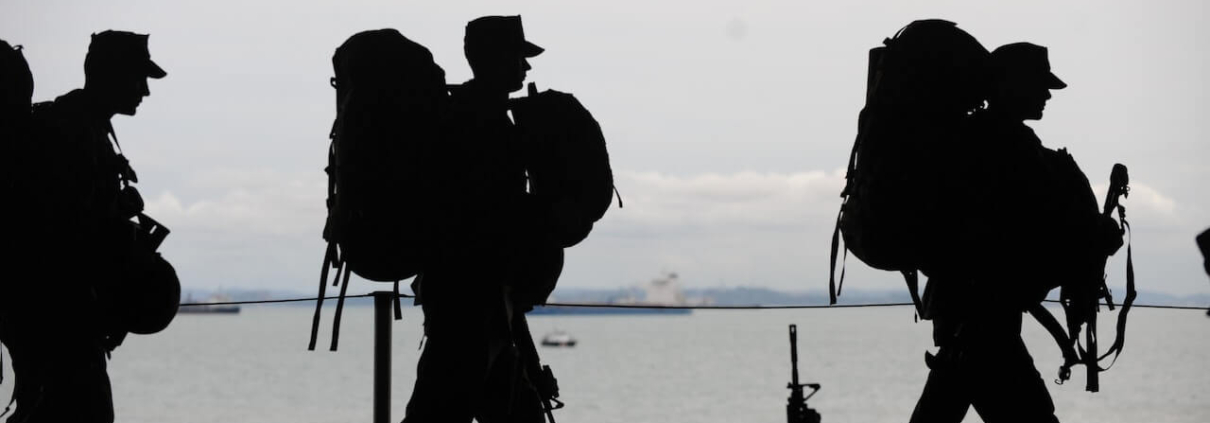 silhouette of military walking along the beach