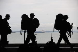 silhouette of military walking along the beach