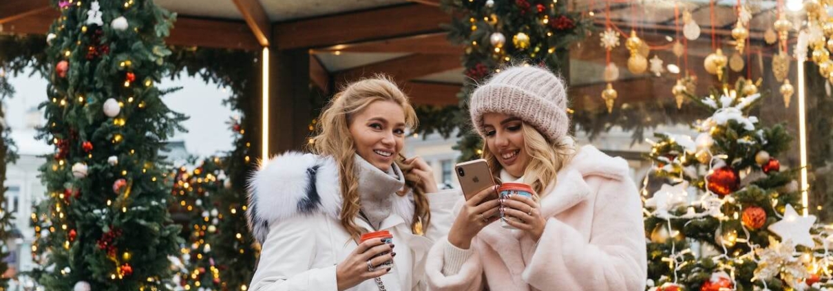 Garland holiday decor- 2 women outdoors at mall adorned with holiday garland and decorations