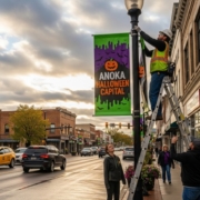 Mock Up Image of Workers installing custom pole banners on a downtown street, showcasing the finished stage of the banner design process.