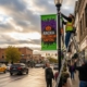 Mock Up Image of Workers installing custom pole banners on a downtown street, showcasing the finished stage of the banner design process.