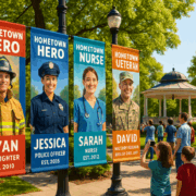 Community park entrance with custom pole banners honoring local heroes including a firefighter, police officer, nurse, and veteran.